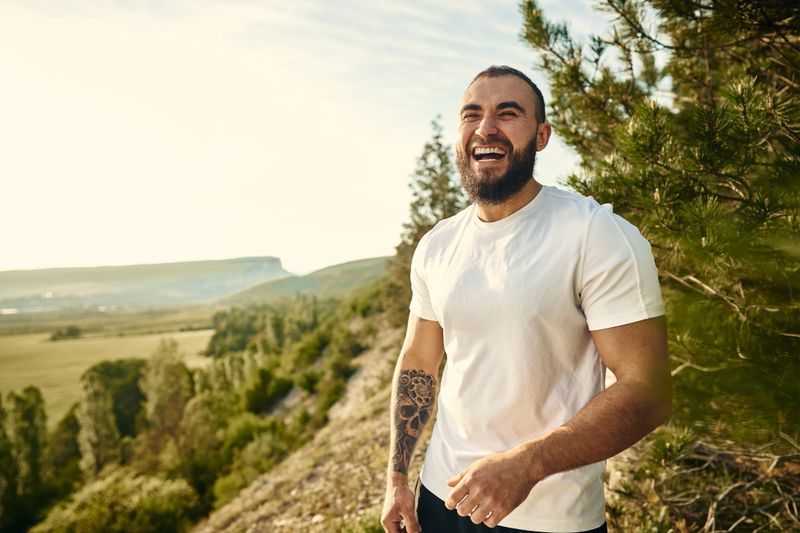 Young bearded man portrait outdoors in the mountains, close up