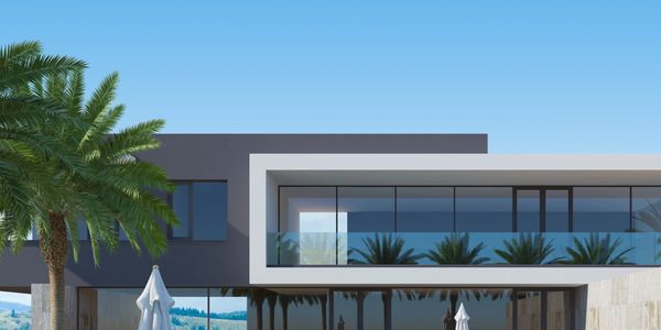 Modern house with a pool and lounge chairs in a sunny setting.