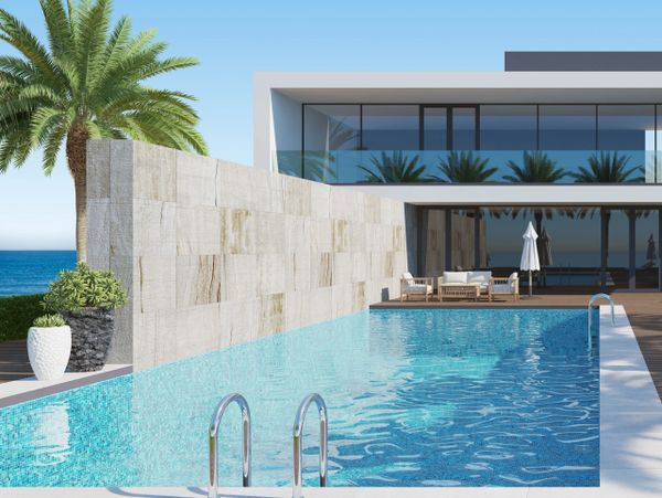 Modern house with a swimming pool and ocean view under clear blue sky.