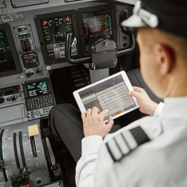 Pilot using a tablet inside an airplane cockpit.