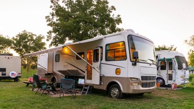 Motorhome parked at a campsite beneath trees