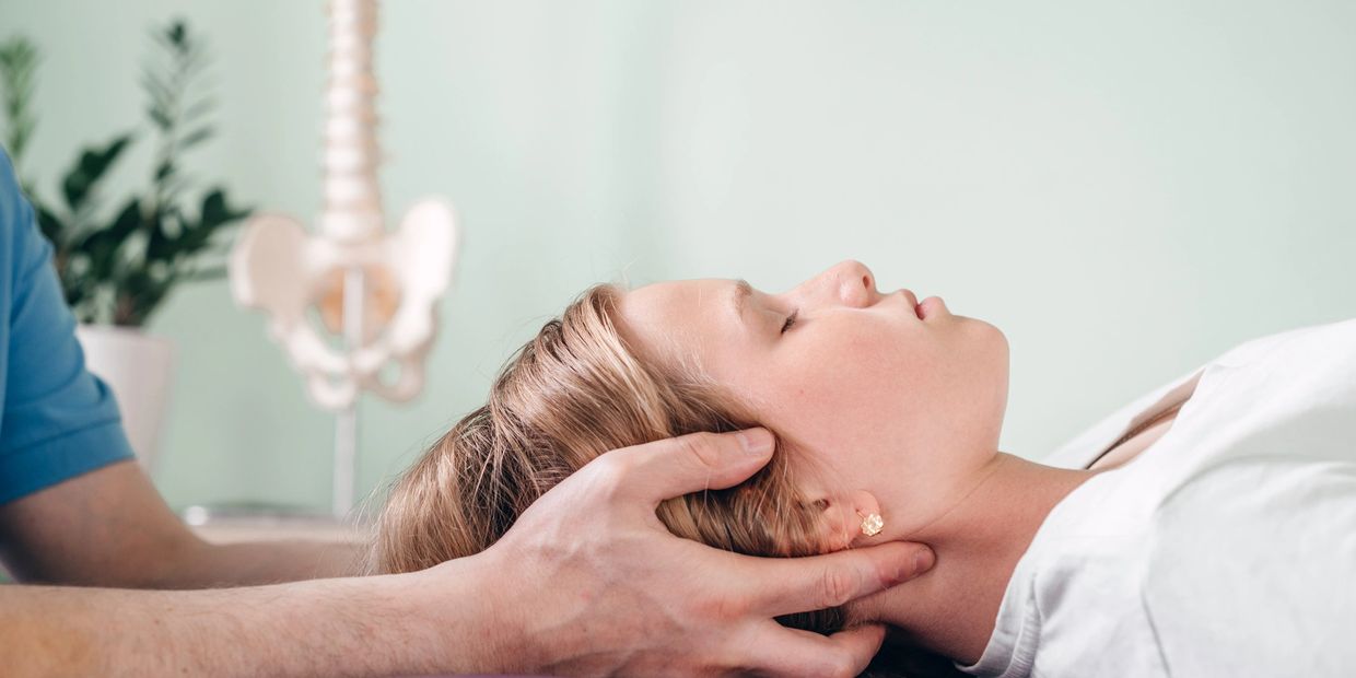Person receiving gentle neck therapy while lying down.