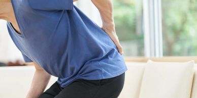Person holding lower back in pain.
