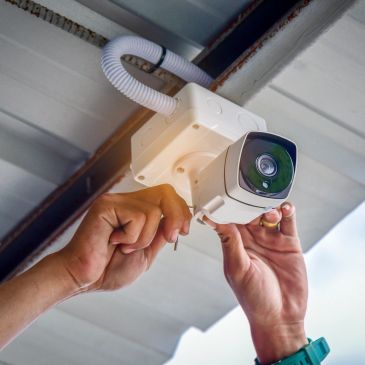 Person installing a surveillance camera.