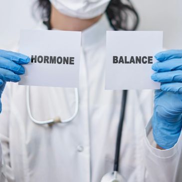Doctor holding papers with "HORMONE" and "BALANCE".