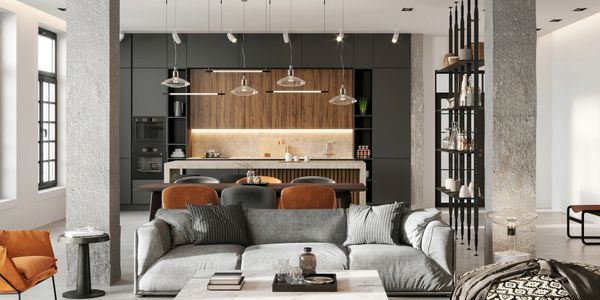 Modern open-plan living room with gray sofa, marble coffee table, and kitchen in the background.