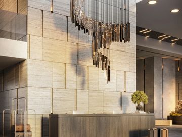 Elegant hotel lobby with a modern chandelier and reception desk.