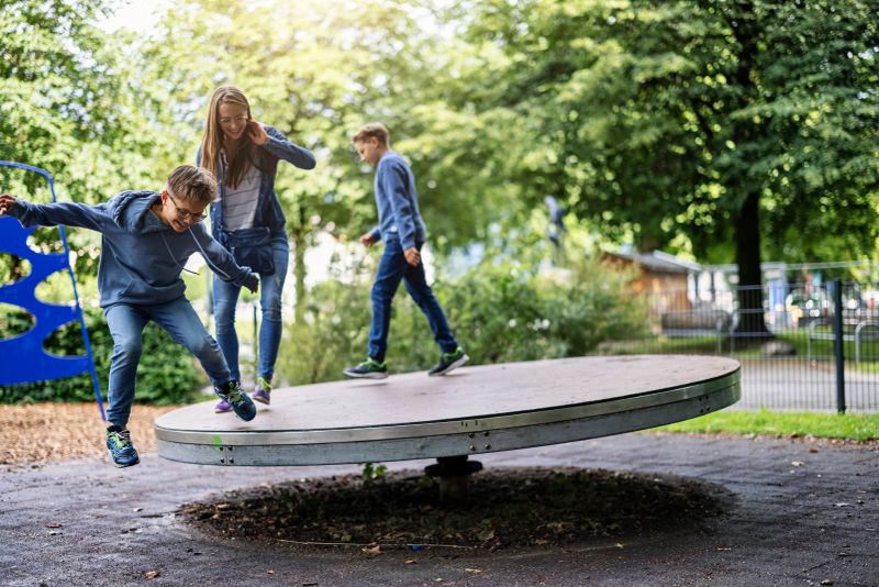 Kids sightseeing the city of Salzburg. Brothers and sister having fun on every playground found during the sightseeing. Kids are walking and running on a giant spinning wheel on the playground.Shot with Canon R5