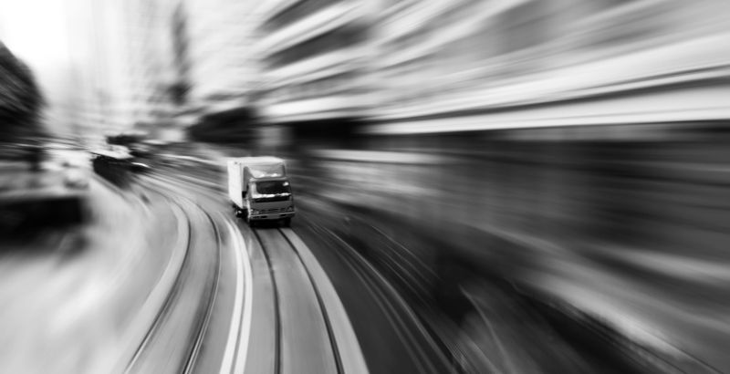 Delivery van driving on city street.