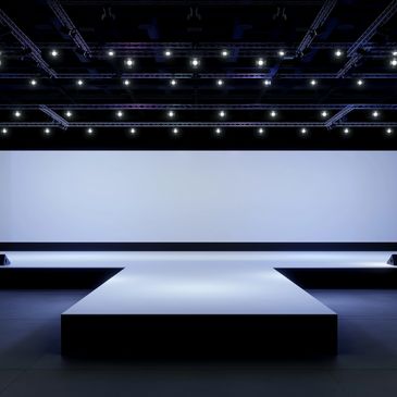 Empty illuminated runway stage with lighting trusses.