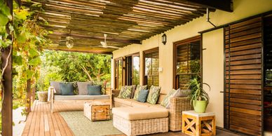 Comfortable porch with outdoor furniture under a reed roof.
