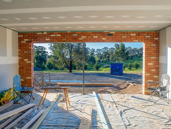 Construction site with brick frame and outdoor view.