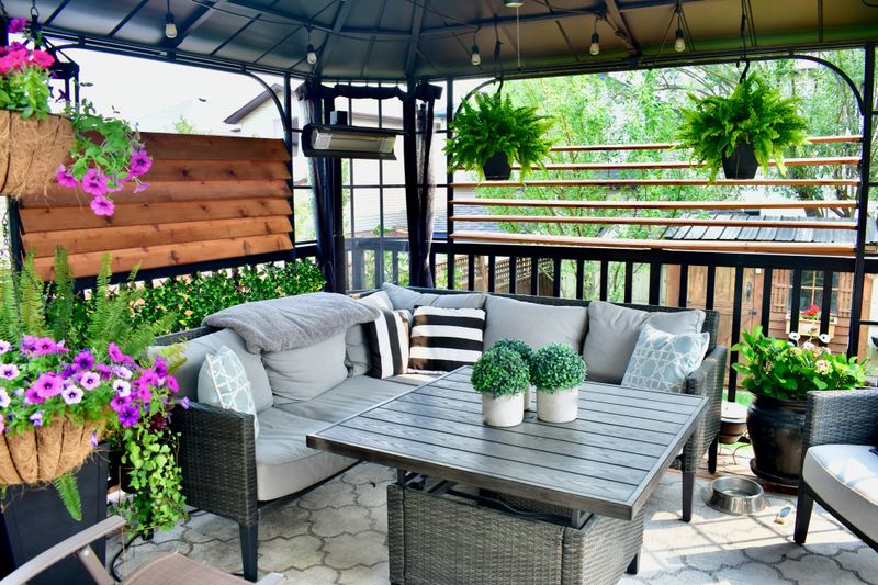 Beautiful seasonal outdoor living room with lush greenery and flowers for spring and summer staycation relaxing.