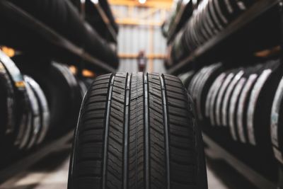 A close-up of a tire in a tire shop aisle.