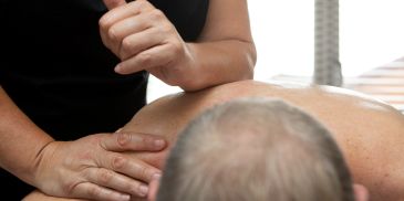 Therapist performing a massage on a client’s back.