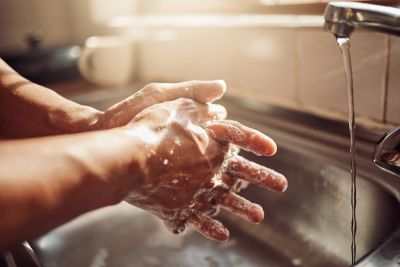 Hands being washed under running water.