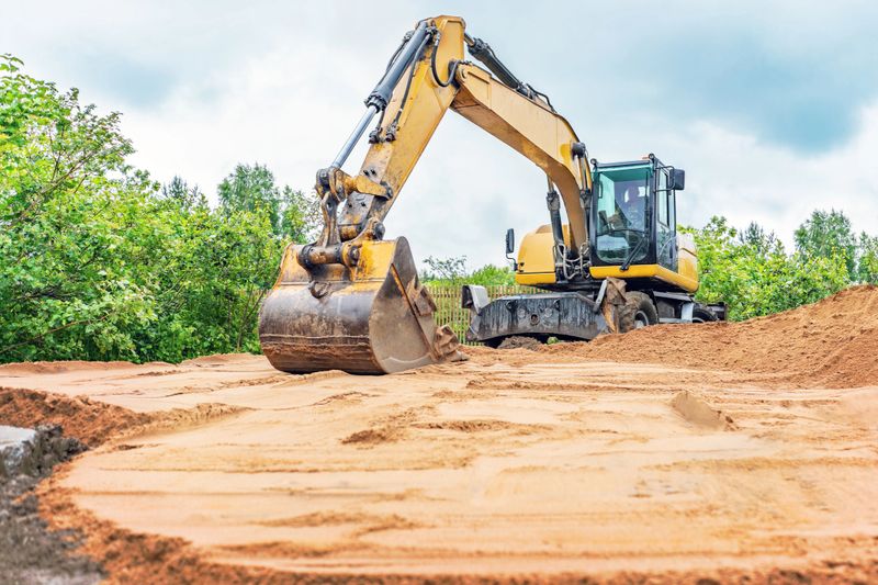 Excavator aligns surface of sand