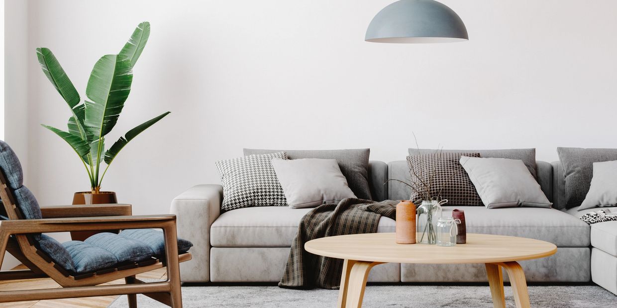 Modern living room with gray sofa, wooden chair, and minimalist decor.