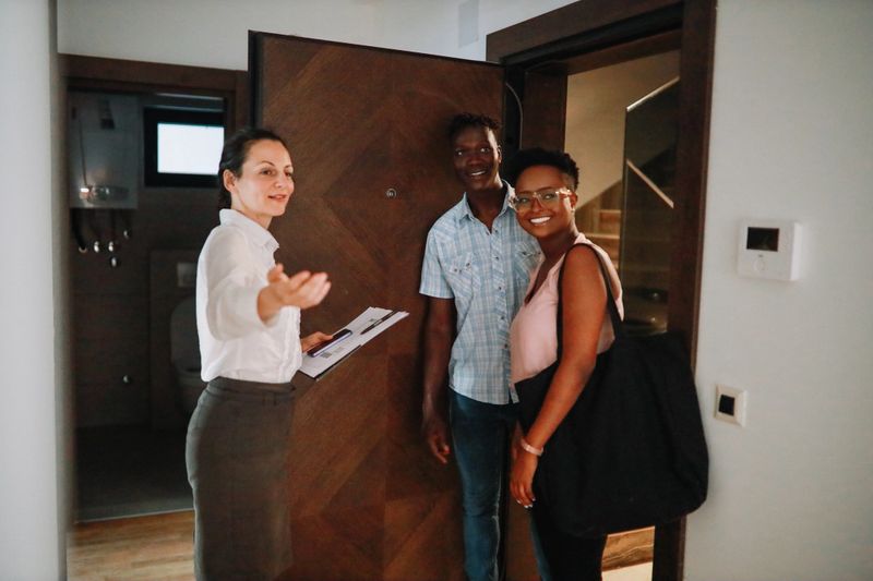 Real estate agent giving the young couple a potential apartment tour.