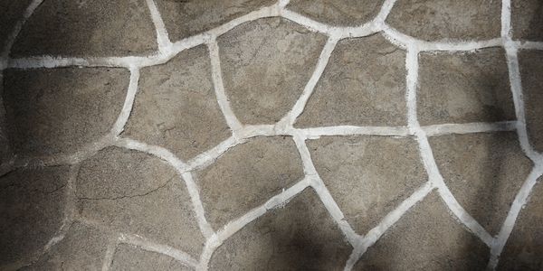 Close-up of irregular stone pavement with white grout lines.