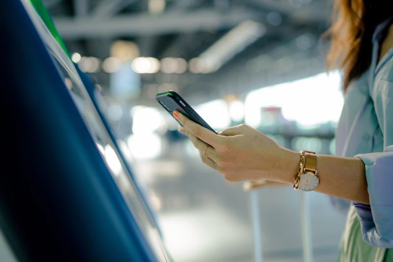 Young Asian woman travelling wearing masks using a machine by plane and doing self check in at the airport