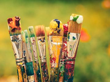 Collection of paintbrushes with colorful paint.