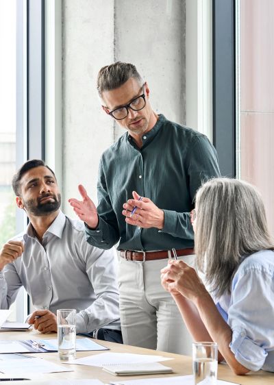 Man discussing with colleagues in office meeting.