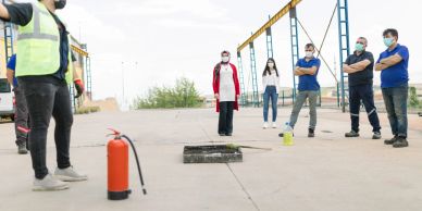 Group observing a safety demonstration outdoors.