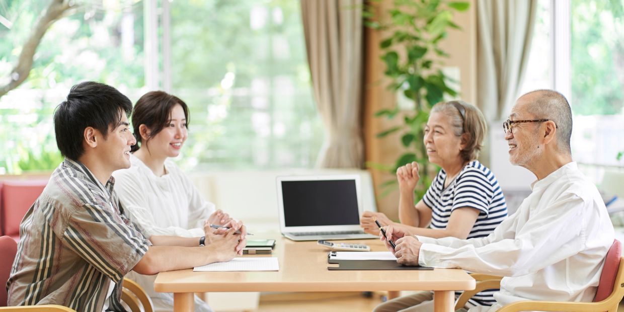 Two couples having a discussion at a table.