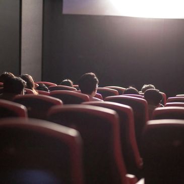 People watching a movie in a dimly lit theater.