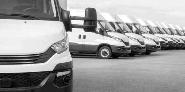 Fleet of white delivery vans parked in a row.