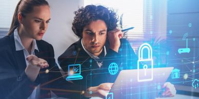 Dois profissionais analisam segurança cibernética em um laptop.