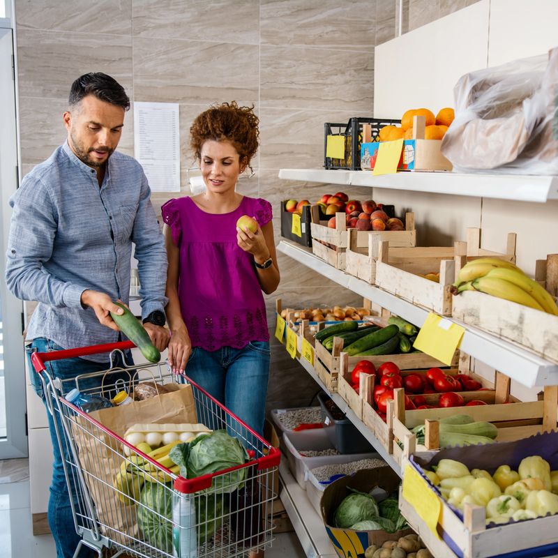 Couple choosing vegetables in a grocery store.