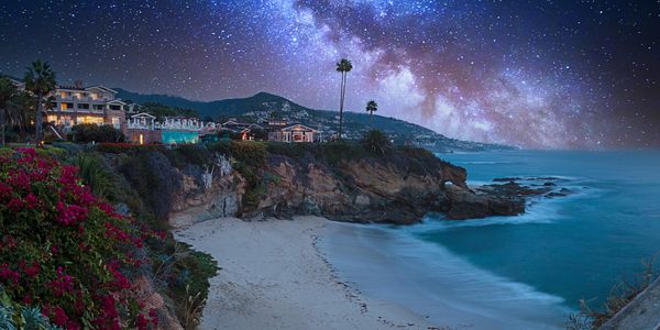 Coastal cliffside under a starry night sky.