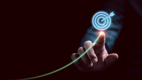 Hand pointing at a glowing target with an arrow.
