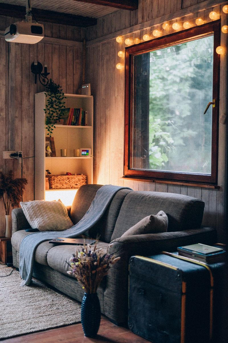 Cozy country house with a boho-style living room and a white-gray plank wall.