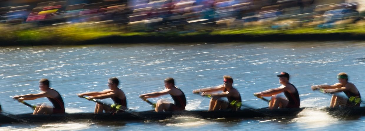 Coach guiding a rower on the water, inspiring excellence.