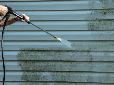 Power washing a dirty exterior wall.