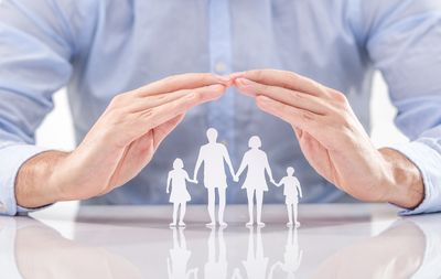 Family being protected by hands. Life Insurance, Annuities, Health Insurance protection