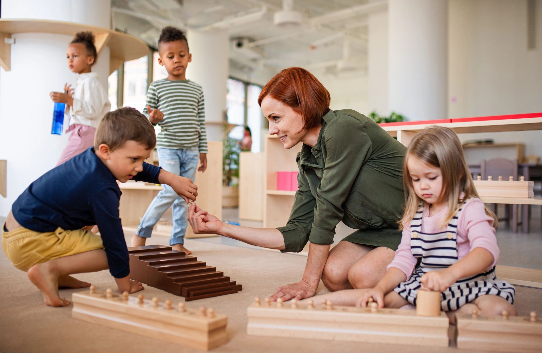 Teacher interacting with children in a classroom.