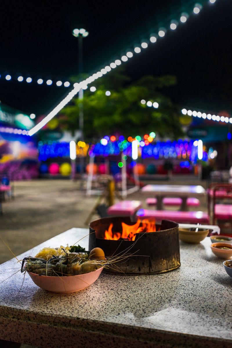 Fresh shrimp and fire stove on stone table with bokeh light at night restaurant