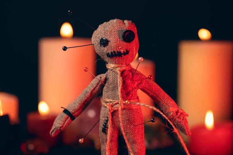 Voodoo Magic concept. Witchcraft with rag doll. Close-up of puppet nipped with needles.