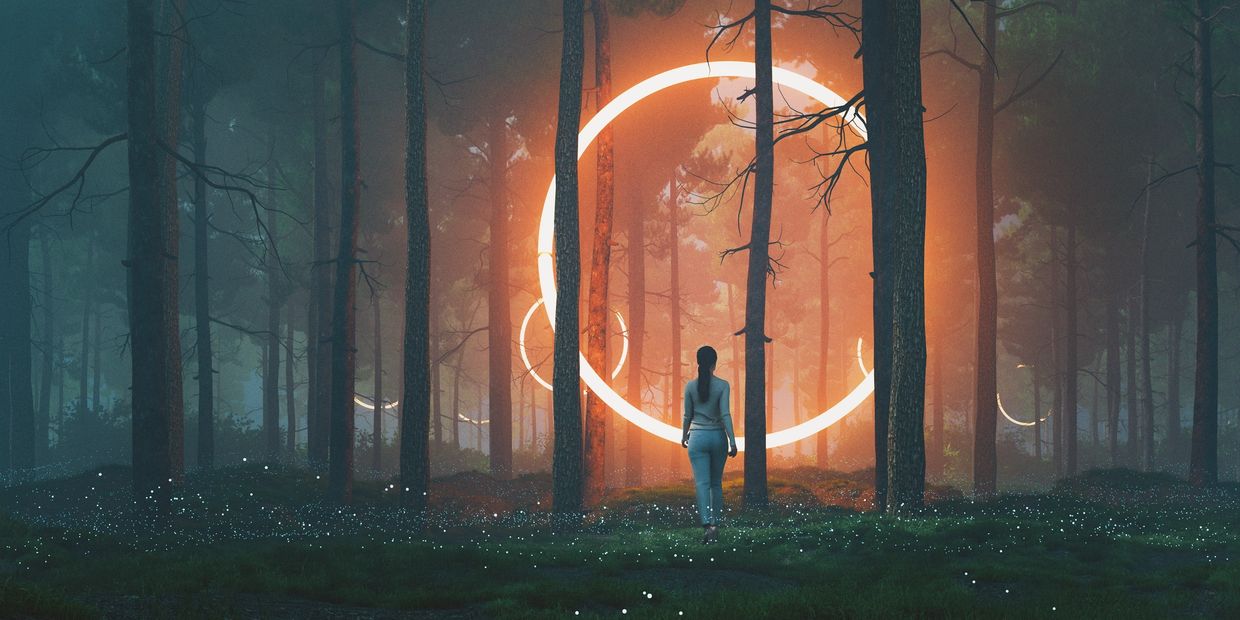 A person walks toward glowing neon rings in a misty forest at dusk.