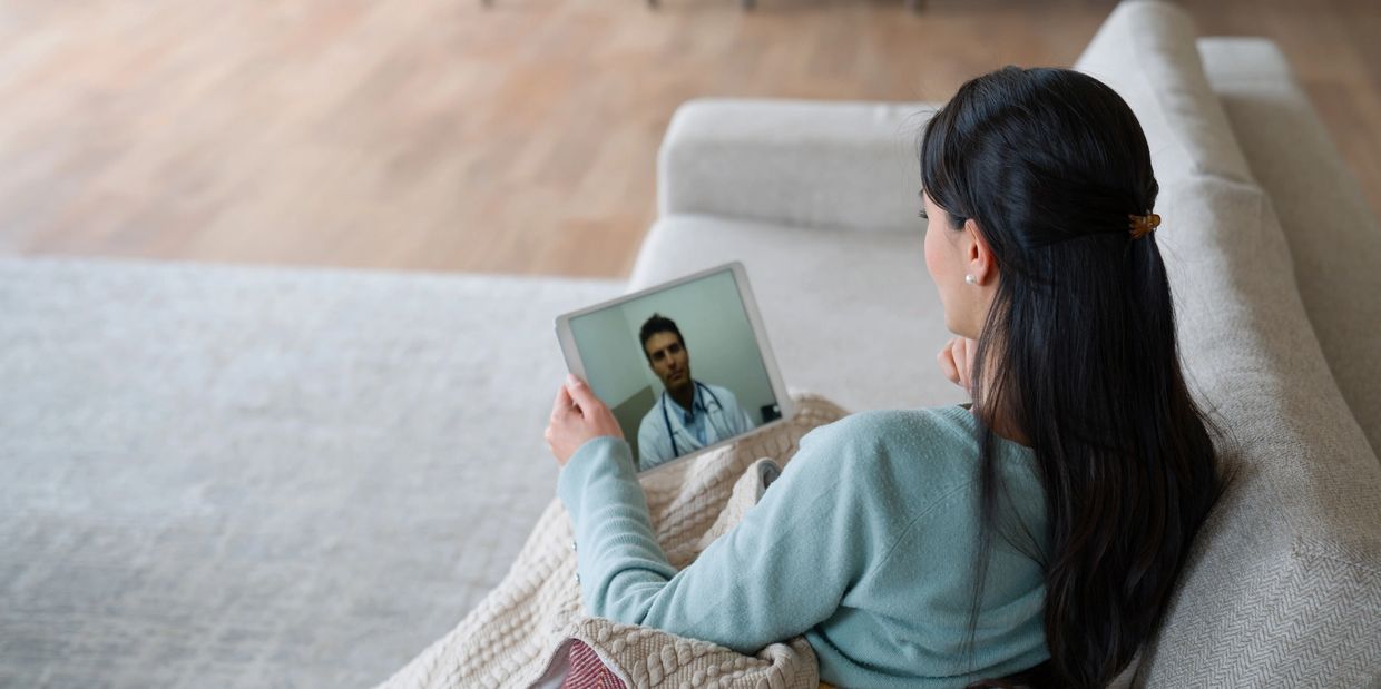 Woman having a video call with a doctor on a tablet.