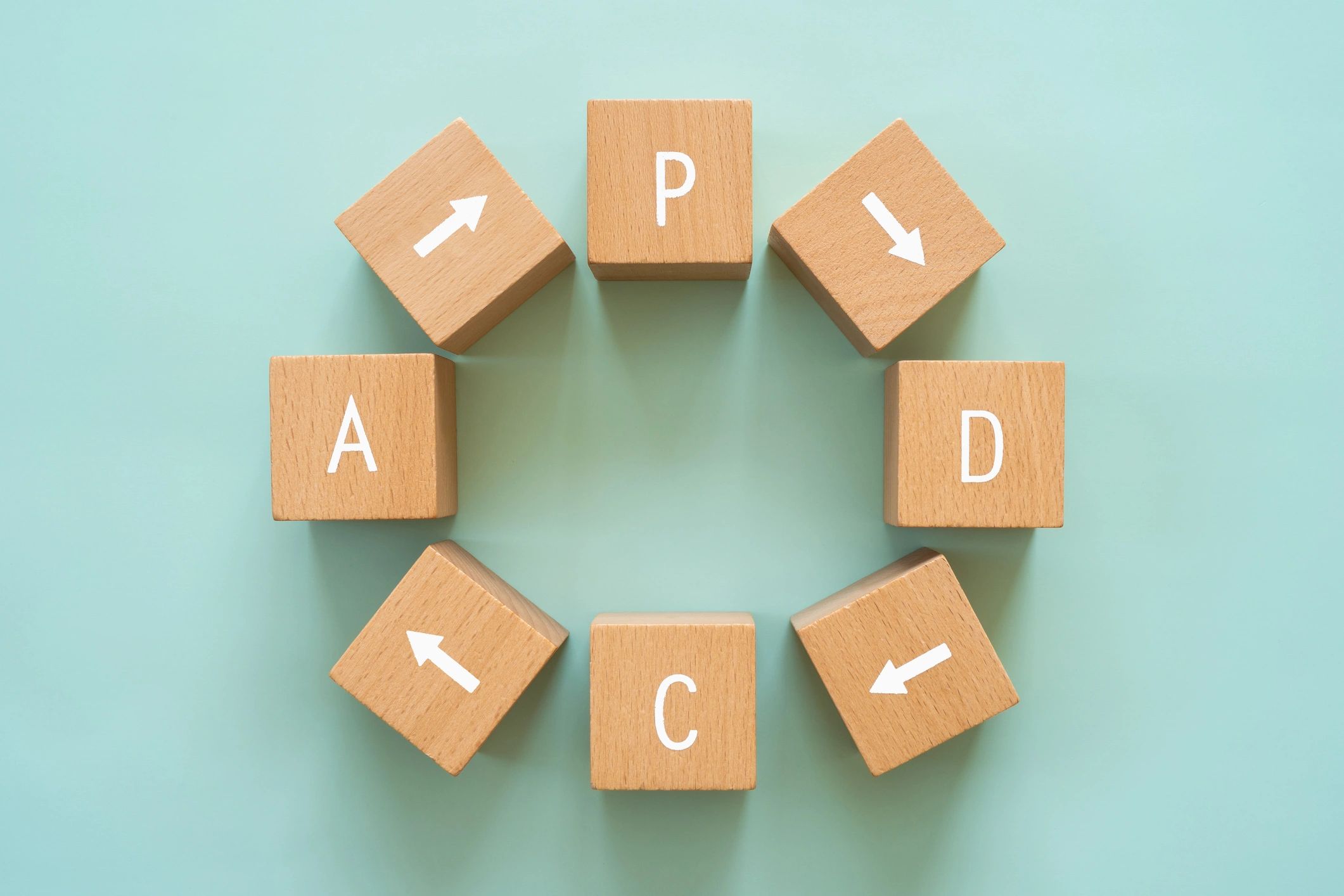 PDCA cycle; Wooden blocks with "PDCA" text of concept.