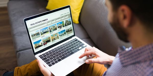 Person browsing real estate listings on a laptop.