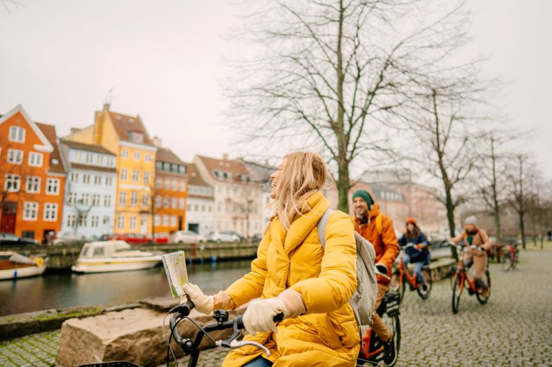 Photo of female travel guide and her group on the bicycles through the town
