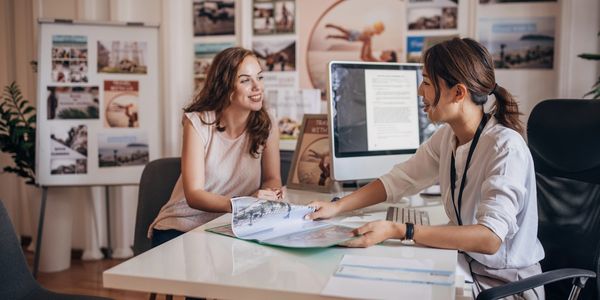 Two women discussing a project at an office desk.