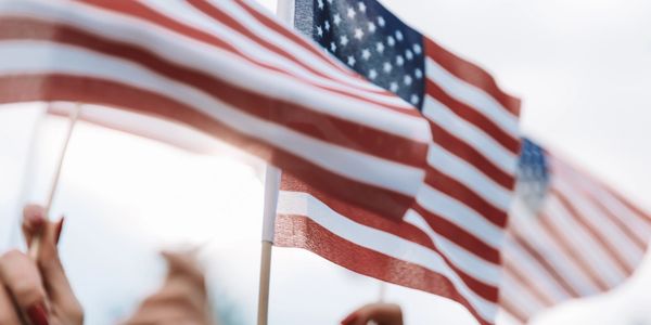 People holding American flags in a bright setting.