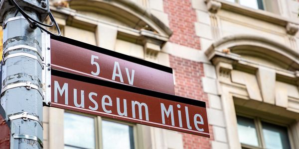 Street sign for 5th Avenue and Museum Mile in a city.